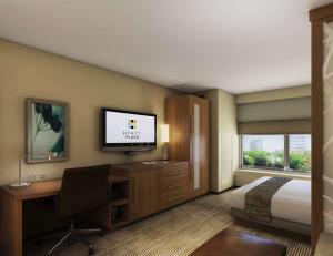 a hotel room with a bed and a desk and a television at Hyatt Place Austin Airport in Austin