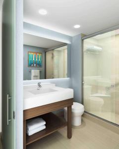 a bathroom with a sink and a toilet and a mirror at Hyatt Place Austin Airport in Austin