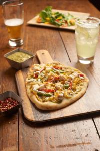 a pizza sitting on top of a wooden table at Hyatt Place Austin Airport in Austin