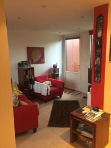 una sala de estar con 2 sillas rojas y una mesa. en Eco House, en Shenley Church End