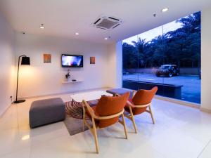 ein Wohnzimmer mit einem Tisch, Stühlen und einem Sofa in der Unterkunft Tune Hotel KLIA Aeropolis (Airport Hotel) in Sepang