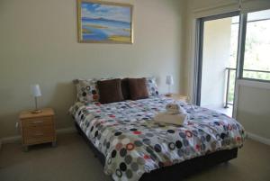 a bedroom with a bed with a teddy bear on it at The Beach Townhouse in Hawks Nest