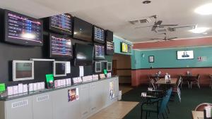 a fast food restaurant with tables and televisions on the wall at Sarina Hotel in Sarina