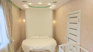 ソチにあるNa Roz Apartmentの緑の天井が特徴のベッドルーム1室(ベッド1台付)