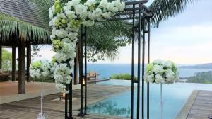 a wedding ceremony with white flowers and a pool at Mora Royal Villa in Senggigi 