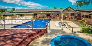 a swimming pool with a blue pool noodle in front of a house at Tanoa Skylodge Hotel in Nadi