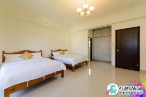 a bedroom with two beds and a chandelier at Sand Po Dang B&B II in Jian