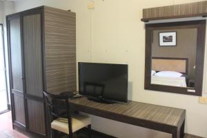 a room with a desk with a television and a mirror at Baan Warabordee in Chiang Rai
