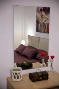 1 dormitorio con 1 cama y 1 mesa con flores en Detached House at Peristeri, en Atenas