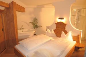 a bedroom with a bed and a bathroom with a sink at Ramsbergerhof in Ramsau am Dachstein