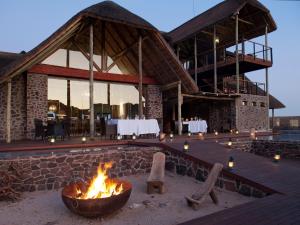 a fire pit in front of a building with a restaurant at Tutwa Desert Lodge in Augrabies