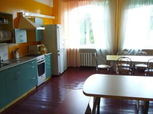 a kitchen with green cabinets and a table and chairs at Apgyvendinimo įstaiga KORNEALITA-ZARASAI in Zarasai