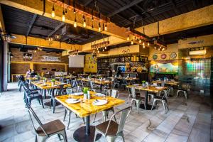un ristorante con tavoli e sedie in una stanza di New Travel Lodge Hotel a Chanthaburi