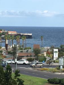 a parking lot with cars parked next to the ocean at Luxurious Street Apartments in Catania