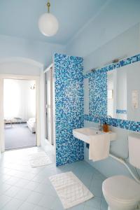 y baño con aseo, lavabo y azulejos azules. en Fink Low Budget Rooms en Viena