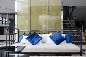 a bed with blue and white pillows on it at Z Sleep Hotel in Hat Yai