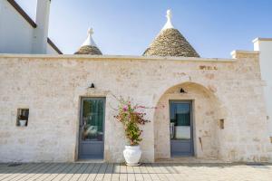 een gebouw met twee deuren en een plant in een vaas bij Trullisia Bed and Breakfast in Alberobello