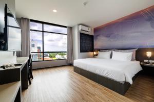 ハジャイにあるZ Sleep Hotelの大きなベッドとデスクが備わるホテルルームです。