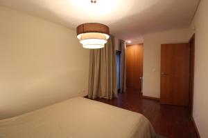 a bedroom with a bed and a large light at Agudela Vista Mar in Lavra