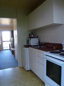 uma cozinha com um lavatório e um fogão forno superior em Lakeside Motel em Queenstown