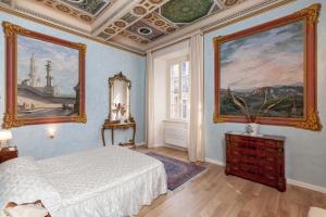 a bedroom with a bed and two paintings on the wall at Ca' De' Principi - Residenza D'epoca in Piegaro +124 photos