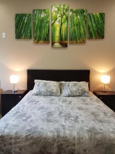 a bedroom with a bed with four paintings on the wall at Studio on Bourdeaux in Panorama