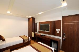 a hotel room with a bed and a television at Prague Hotel in Ho Chi Minh City