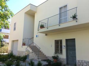 ein weißes Haus mit einer Treppe und einer Tür in der Unterkunft Pensione Afrodite in Metaponto