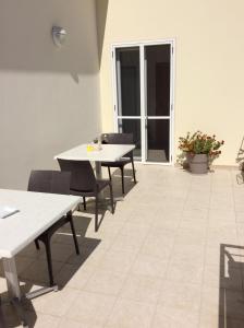 een kamer met tafels en stoelen en een patio bij Pensione Afrodite in Metaponto