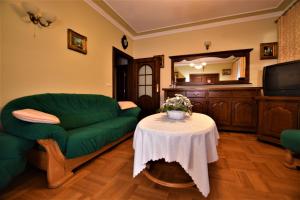 a living room with a green couch and a table at Dwor Osieczek in Pniewy