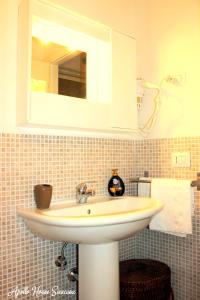 シラクーサにあるApollo House Ortigia Siracusaのバスルーム(白い洗面台、鏡付)
