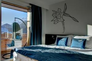 a bedroom with a bed with blue pillows and a window at Sissi Park Haus im Ennstal in Haus im Ennstal