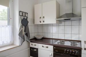 cocina con armarios blancos y fogones en Ferienwohnung Bärbel en Essen
