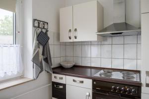 a kitchen with white cabinets and a stove at Ferienwohnung Bärbel in Essen +11 photos