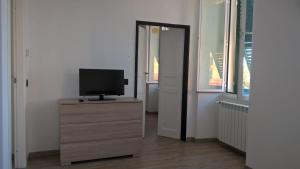 a television on a dresser in a room with a door at Camogli Golfo Paradiso la casa del Comandante in Camogli