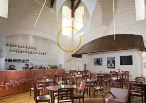 a dining room with tables and chairs and a bar at Dartington Hall in Totnes