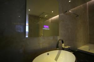a bathroom with a sink and a mirror at First Hotel in Guri