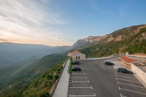 a road with cars parked on the side of a mountain at Hotel Sokoline in Danilovgrad