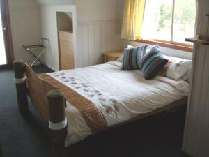 a bedroom with a bed with pillows and a window at Beachs 'n Greens in Greens Beach