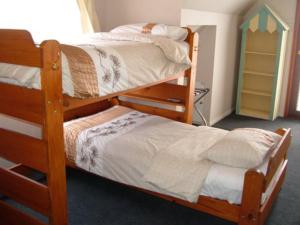 a bedroom with two bunk beds and a small childoir at Beachs 'n Greens in Greens Beach