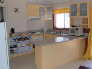a kitchen with a counter top and a microwave at Beachs 'n Greens in Greens Beach