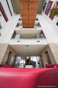 a room with a red couch and a staircase at Eureka Palace Hotel Spa Resort in Cassibile