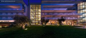 a large building with a lawn in front of it at Eureka Palace Hotel Spa Resort in Cassibile