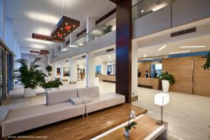 a lobby with a white couch in a building at Eureka Palace Hotel Spa Resort in Cassibile