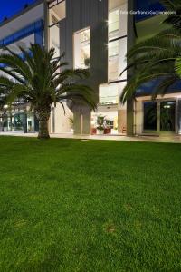 a palm tree in a yard in front of a building at Eureka Palace Hotel Spa Resort in Cassibile