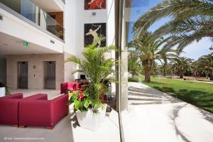 a house with a red couch and palm trees at Eureka Palace Hotel Spa Resort in Cassibile