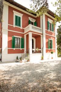 a house with green shuttered windows and a driveway at B&B Villa Regina in Pisa