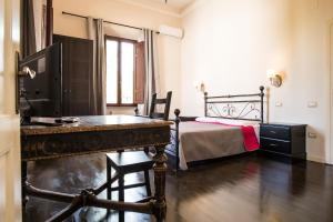 a bedroom with a bed and a desk in it at B&B Villa Regina in Pisa