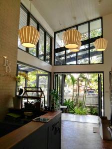 a lobby with large windows and two chandeliers at 18 In Town Homestay in Chiang Mai