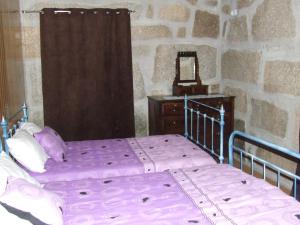 a bedroom with a purple bed and a mirror at Casa da Bôcha in Cativelos